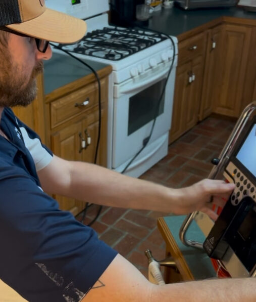 An Anderson technician working at a floor register during a duct cleaning service